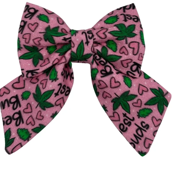 The 420 Best Buds Pink Sailor Bowtie for little dogs and cats features a pink fabric adorned with green cannabis leaves, black 420 Best Buds text, and small black and pink hearts.