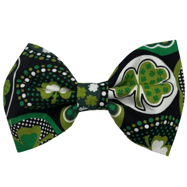 The Irish Shamrock Doggy Bowtie showcases a stylish black background adorned with vibrant green and white shamrocks and dots.