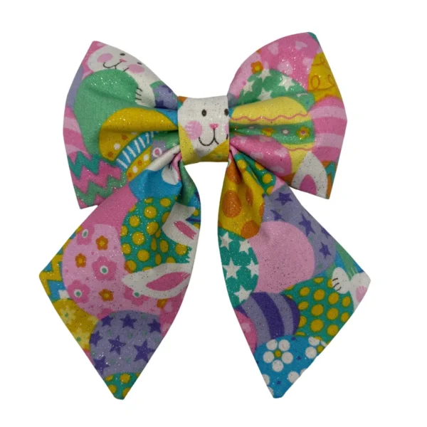 The Hoppy Easter Sparkle Sailor Pet Bowtie is a vibrant, decorative accessory featuring playful designs like smiling bunnies and decorated eggs. Its glittery finish enhances its festive appeal, perfect for any pet celebrating in style.