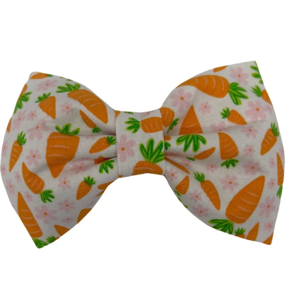 The Hoppy Harvest Pet Bowtie showcases a charming bow with lively orange carrots and dainty pink flowers on a clear white fabric, bringing whimsy to your pets look.